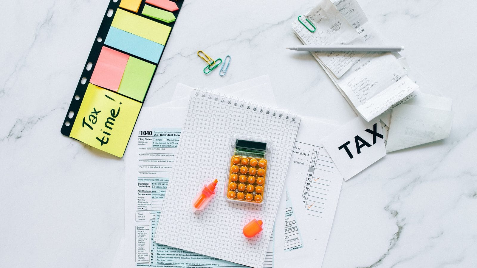 Payroll being run for a small business, payslips and figures on a desk